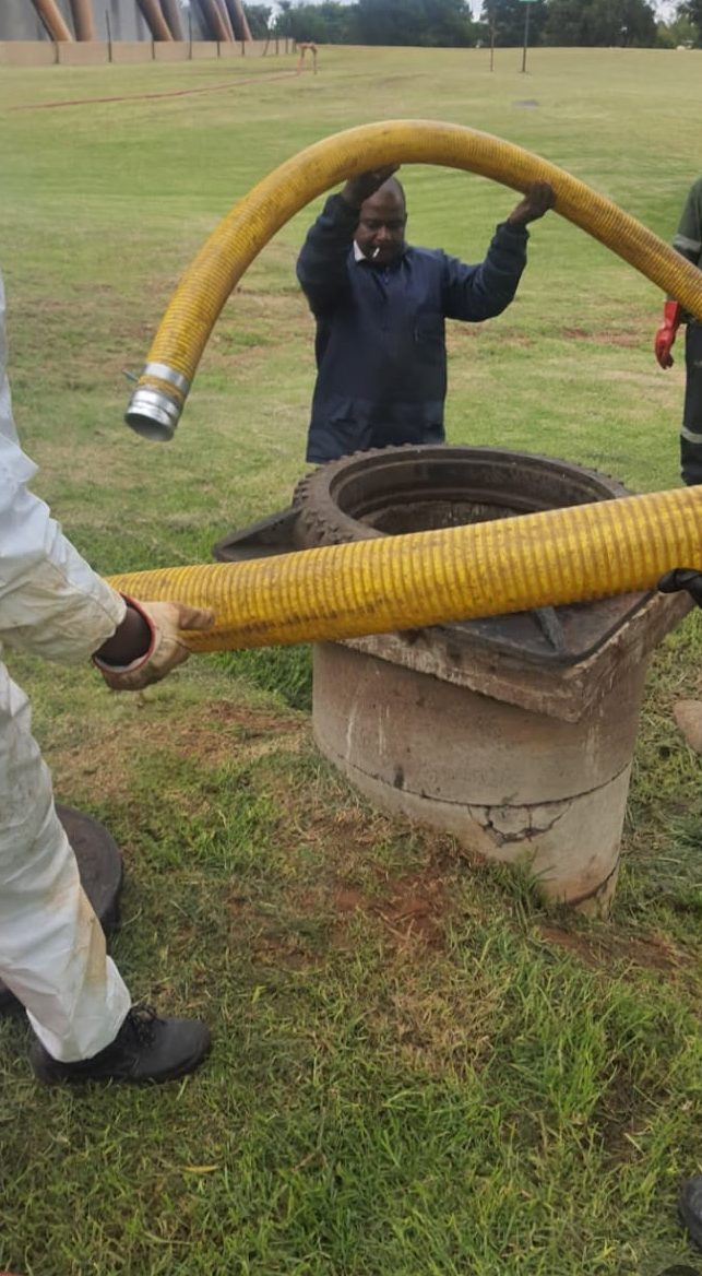 Crew guiding a vacuum loading hose